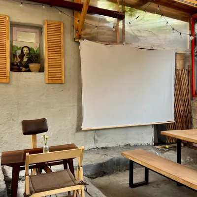 A projector screen on the stone wall under the roof