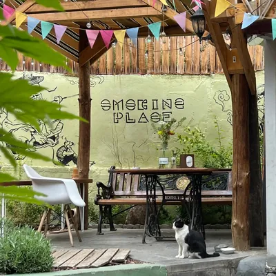 The smoking place: a mural wall, bunting and an old sewing-machine table